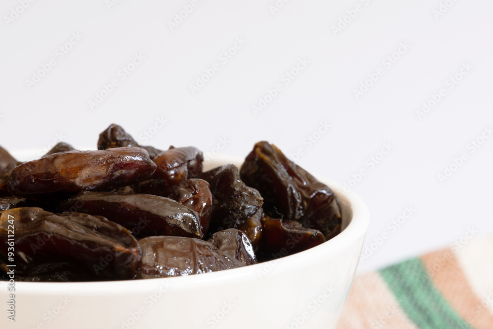 Portion of dates inside a white bowl photographed close up Portion of dates inside a white bowl photographed close up