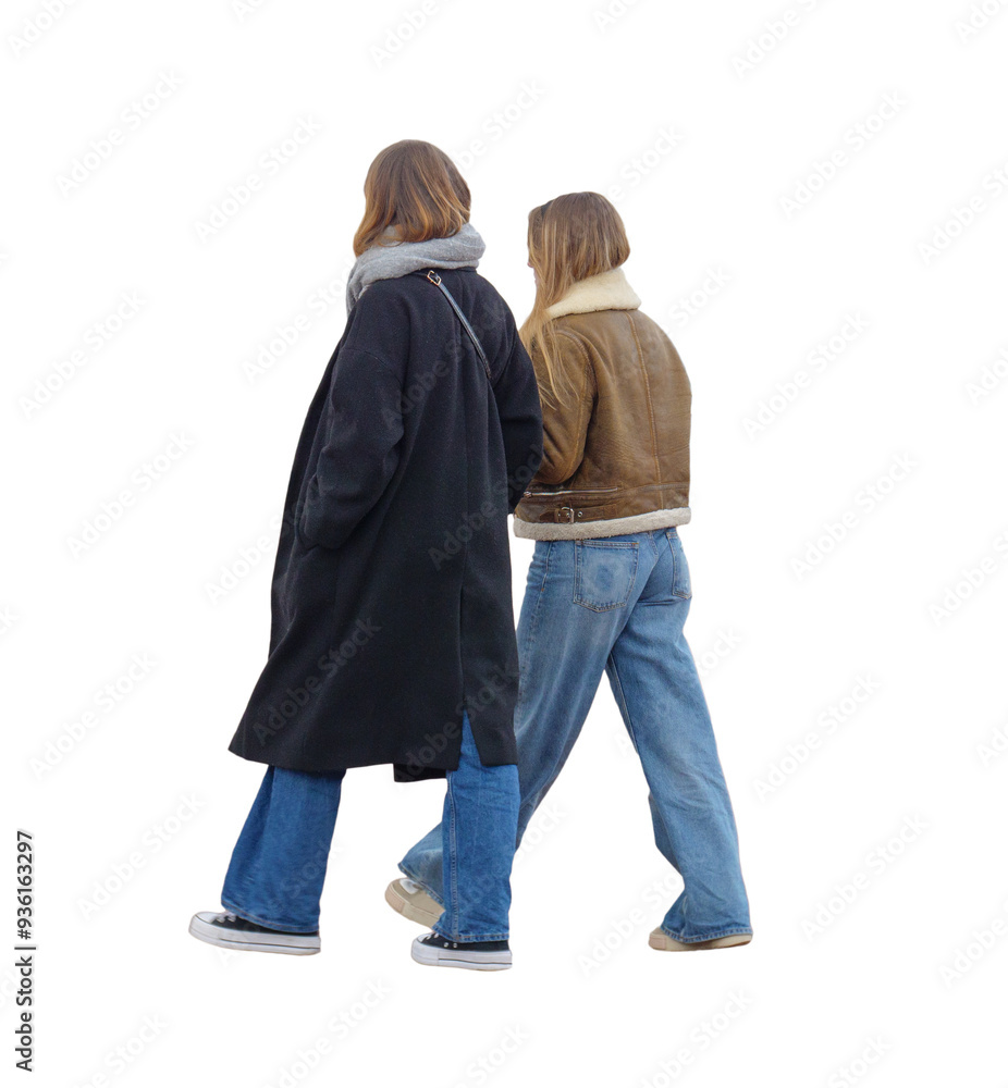 Deux femmes qui marchent côte à côte, vêtues de jeans et vestes chaudes, elles sont  vues de profil, c'est l'hiver