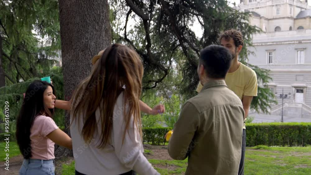 A group of friends cheers with colorful cups in a park, smiling and enjoying a casual outdoor celebration. Concept of friendship and joy. A group of friends cheers with colorful cups in a park, smiling and enjoying a casual outdoor celebration. Concept of friendship and joy.