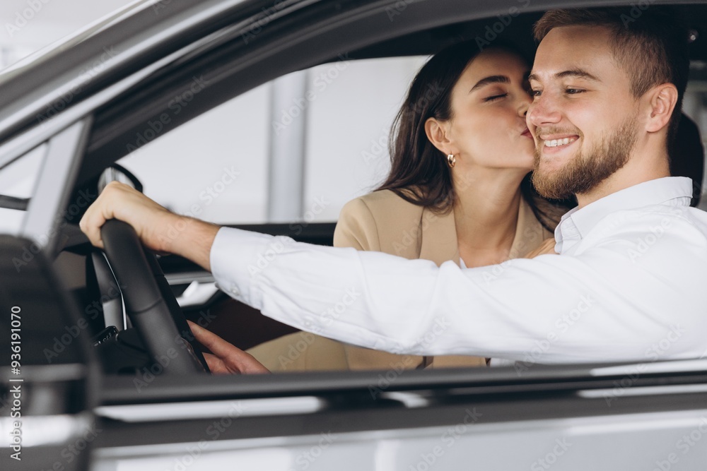 Portrait of smiling beautiful couple sitting in modern luxury car, happy excited young man and woman buying new car in dealership. Portrait of smiling beautiful couple sitting in modern luxury car, happy excited young man and woman buying new car in dealership.