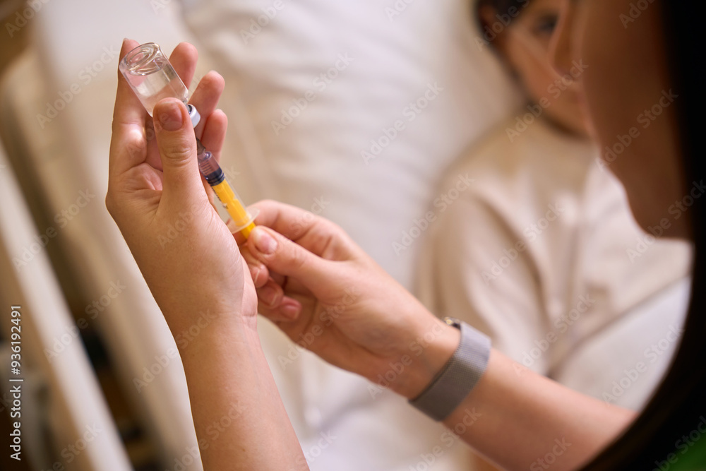 Health worker draws medicine into a syringe for injection Health worker draws medicine into a syringe for injection