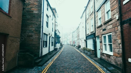 People walking along the quite streets of Staithes a sleepy fishing village on the Yorkshire coast of England. With cobbled streets and old stone built houses. Harbor walls and friendly public houses.