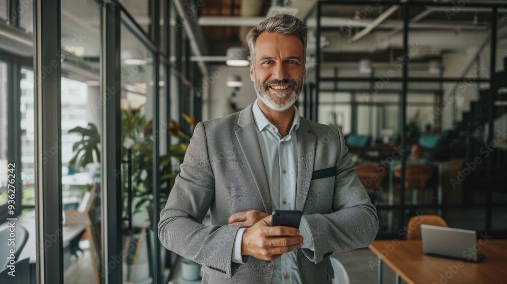 Businessman with good personality smiling happily holding a mobile phone in the office Ready for the company's operations Businessman with good personality smiling happily holding a mobile phone in the office Ready for the company's operations