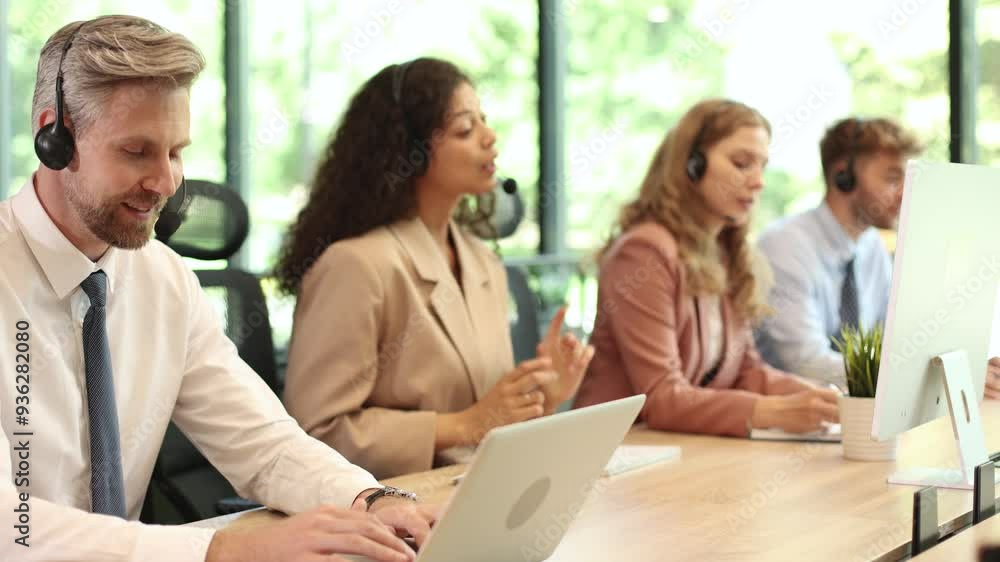 Call center worker accompanied by his team. Smiling customer support operator at work. Call center worker accompanied by his team. Smiling customer support operator at work.