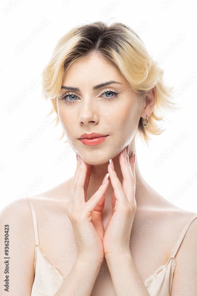 A young blonde girl with clear skin in a satin top. Beauty portrait of a woman on a white background in the studio.