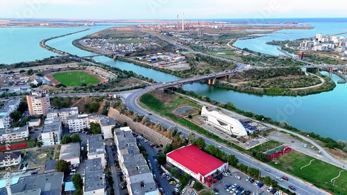 Reverse aerial view of a fish like structure and a industrial area behind it near Navodari photo