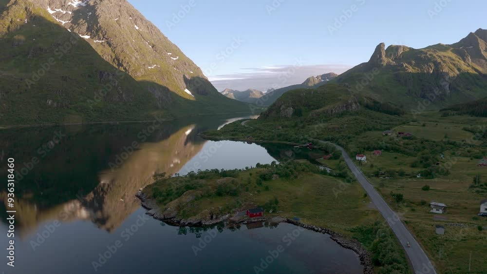 Idyllic red house on Lofoten island, Norway. Nature with sea, fjord, mountain and water reflections