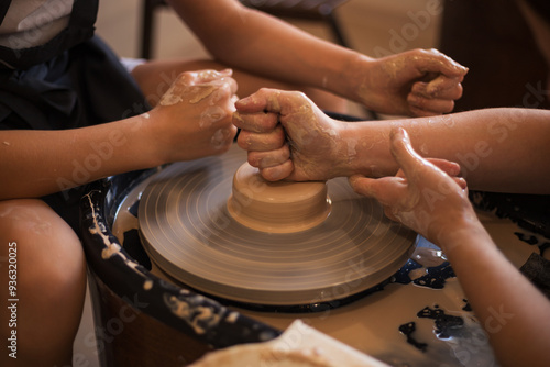 Hands of young girl and a teenage creating plate on a Potter's w photo