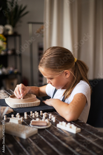 Portrait of girl working with ceramic clay in modern pottery wor photo