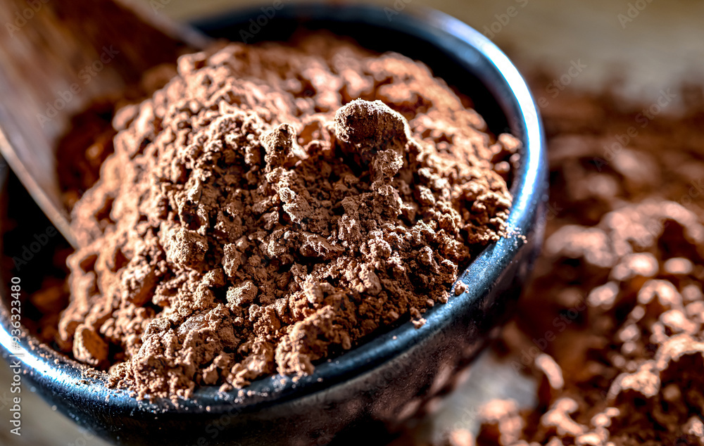 Bowl of cocoa powder on wooden table Bowl of cocoa powder on wooden table