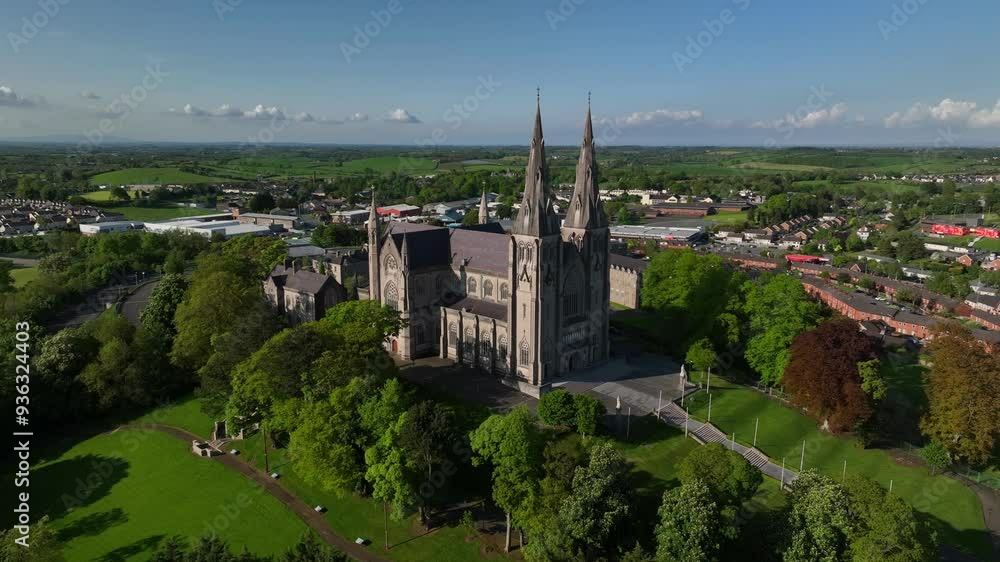 St. Patrick's Cathedral, County Armagh, Northern Ireland, May 2023. Drone orbits clockwise around the Gothic Revival architecture with twin spires revealing Armagh town bathed in golden sunlight. St. Patrick's Cathedral, County Armagh, Northern Ireland, May 2023. Drone orbits clockwise around the Gothic Revival architecture with twin spires revealing Armagh town bathed in golden sunlight.