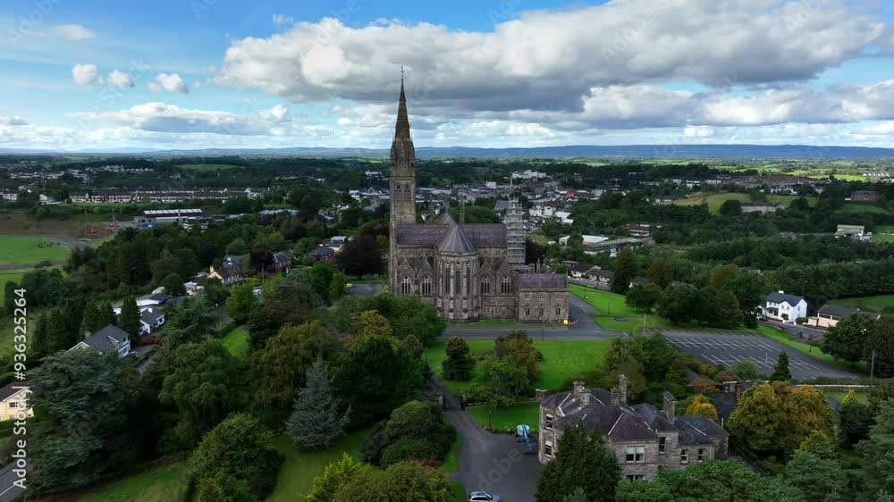 St. Macartan's Cathedral, County Monaghan, Ireland, September 2022. Drone orbits clockwise pushing closer to the Gothic Revival architecture surrounded by green trees and gardens under a overcast sky. St. Macartan's Cathedral, County Monaghan, Ireland, September 2022. Drone orbits clockwise pushing closer to the Gothic Revival architecture surrounded by green trees and gardens under a overcast sky.