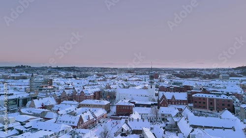 Aerial white winter cityscape of the Aalborg old town covered with snow. Christmas holiday outdoor skating rink at Budolfi Church (Budolfi Kirke). North Jutland, Denmark  photo