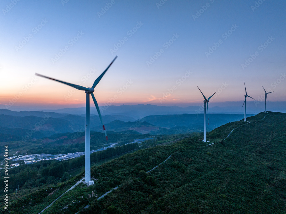 view of wind power station on hill at sunrise view of wind power station on hill at sunrise