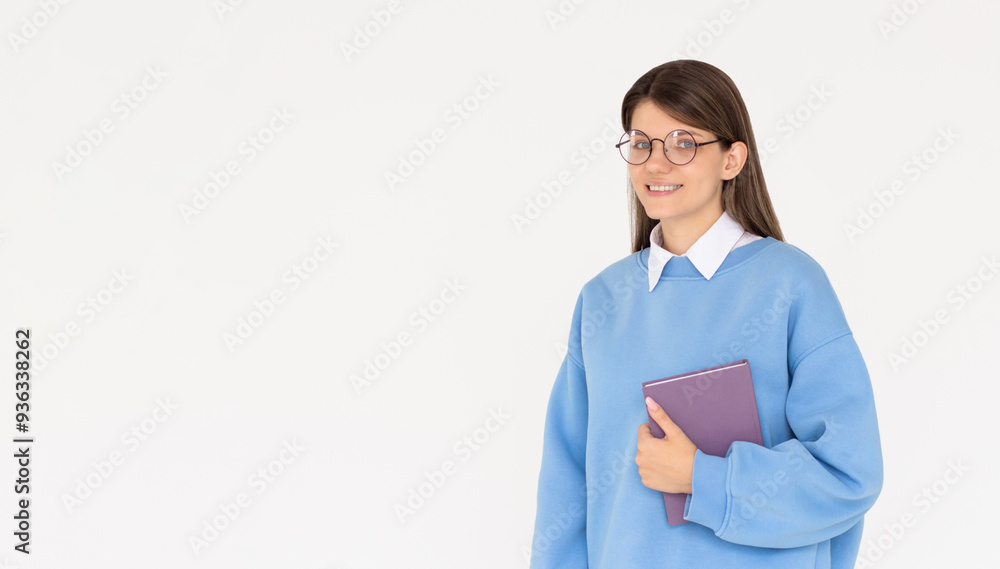 Caucasian girl student in blue sweatshirt with folder, books, notebook, notepad in hands with glasses smiling isolated on white studio background, copy space Caucasian girl student in blue sweatshirt with folder, books, notebook, notepad in hands with glasses smiling isolated on white studio background, copy space