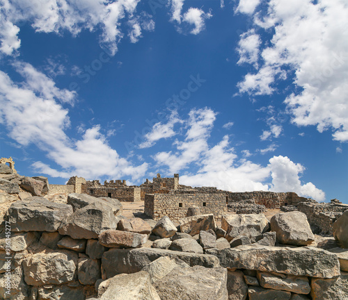 Ruins of Azraq Castle (Qasr al-Azraq) is a crusader castle (300AD),  central-eastern Jordan, 100 km east of Amman, Jordan. Against the background of a beautiful sky with clouds photo