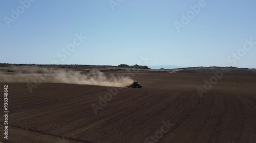 4K Lateral Drone Footage of Tractor Working in Dry, Dusty Field in Piera, Highlighting Climate Change and Water Scarcity
 photo