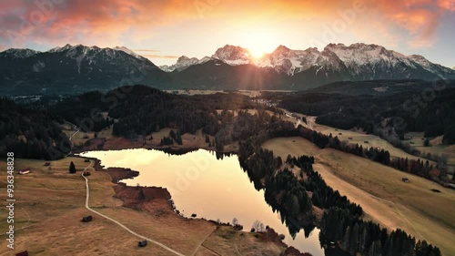 Majestic mountain lake sunrise scenery. Aerial view of the German Alps with the magnificent colorful sky reflected in the water. Slow and smooth backward motion. 
 photo