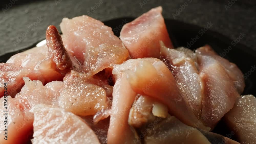 Pieces of herring fish are lying on a plate close-up macro. Herring fillet in oil and spices. Marinated cut fish for appetizer. Seafood products Pieces of herring fish are lying on a plate close-up macro. Herring fillet in oil and spices. Marinated cut fish for appetizer. Seafood products