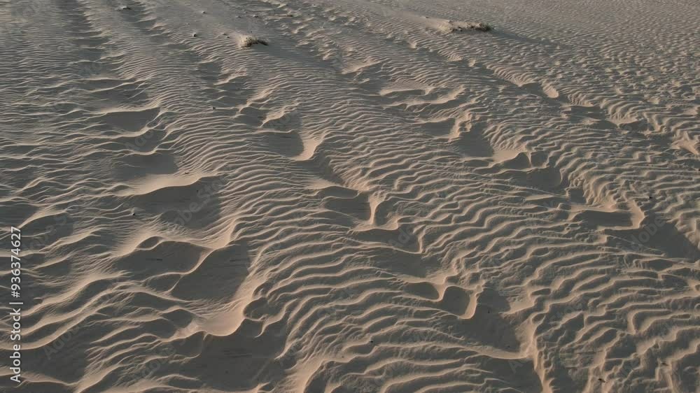 Pessoa andando nas dunas no por do sol com imagem de drone