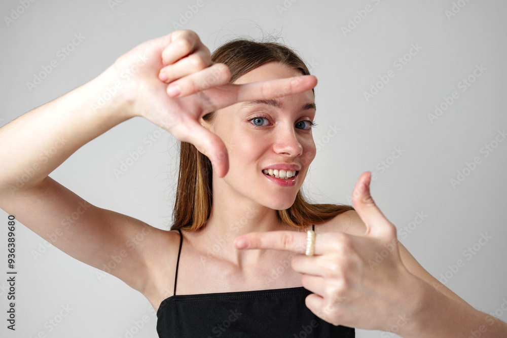 Young Woman Framing a Scene With Her Hands Against a White Background Young Woman Framing a Scene With Her Hands Against a White Background