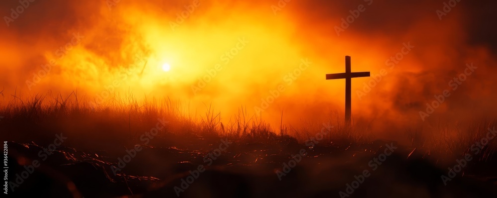 Obraz premium A serene sunset with a cross silhouetted against a vibrant, orange sky, symbolizing hope and faith in difficult times.