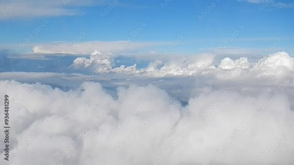 Cumulus clouds, horizon of blue sky and Brocken spectre with glory and shadow of plane on clouds - aerial view through window with traces of frost during flight in clouds. Cumulus clouds, horizon of blue sky and Brocken spectre with glory and shadow of plane on clouds - aerial view through window with traces of frost during flight in clouds.