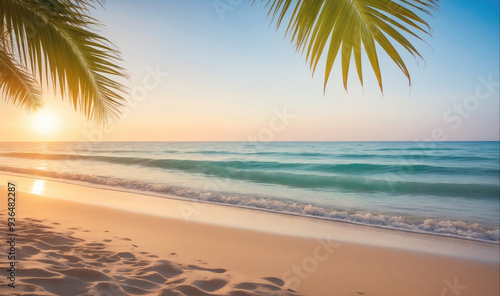 The sun sets over the ocean, casting a golden glow on the sandy beach