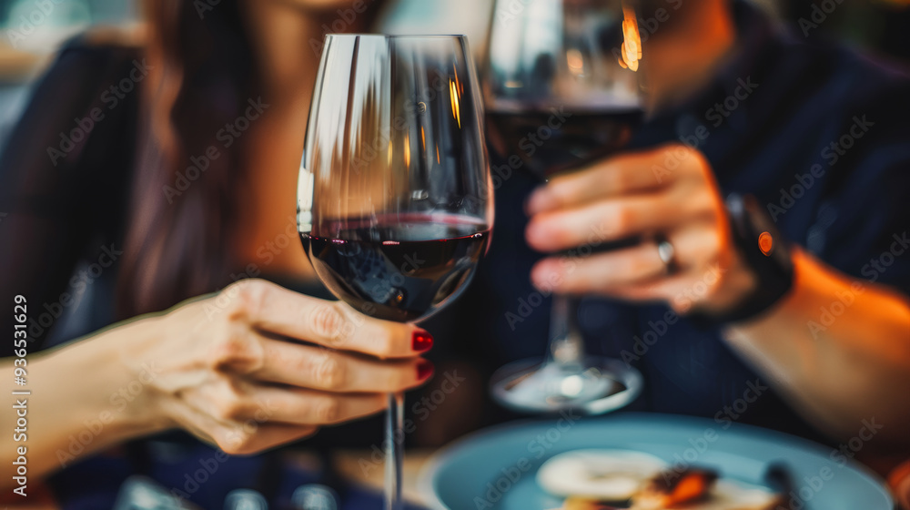 Couple sharing an intimate moment over red wine, toasting to their relationship. Perfect for romantic promotions and festive dining experiences. Couple sharing an intimate moment over red wine, toasting to their relationship. Perfect for romantic promotions and festive dining experiences.
