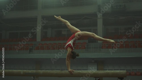 Gymnast in red practicing on balance beam
