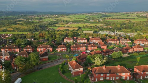 Yorkshire's housing district: Aerial drone shot of red brick council housing in the morning sun, showcasing residents and active streets in the UK.