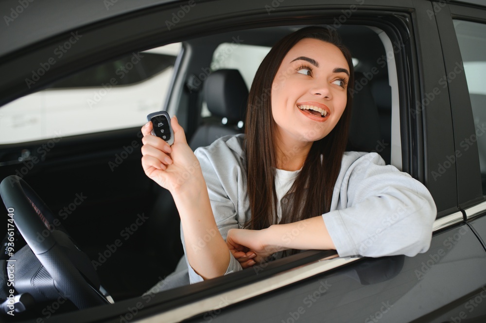 Young woman sitting in car holding keys Young woman sitting in car holding keys