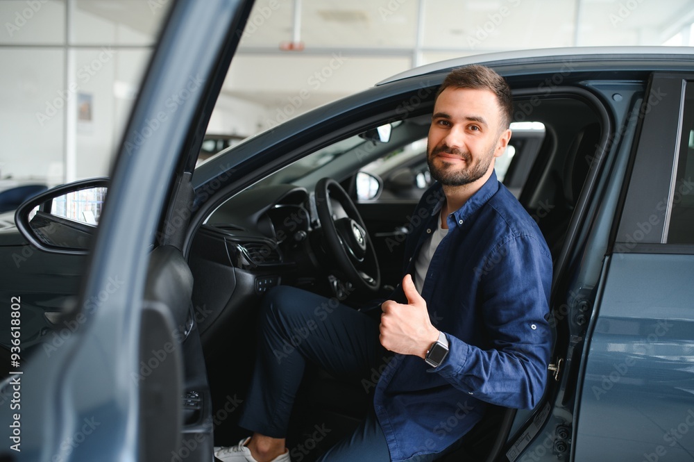 Young man is choosing a new vehicle in car dealership Young man is choosing a new vehicle in car dealership