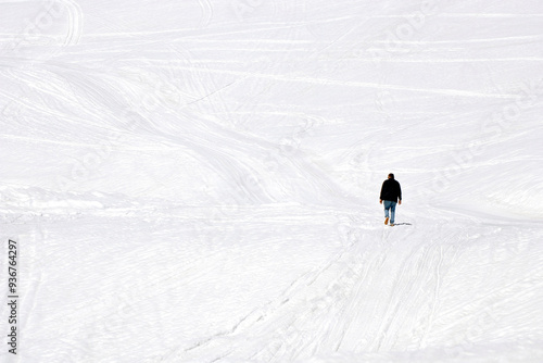 lonely man walking on snow covered caucasus mountain at georgia gudauri photo