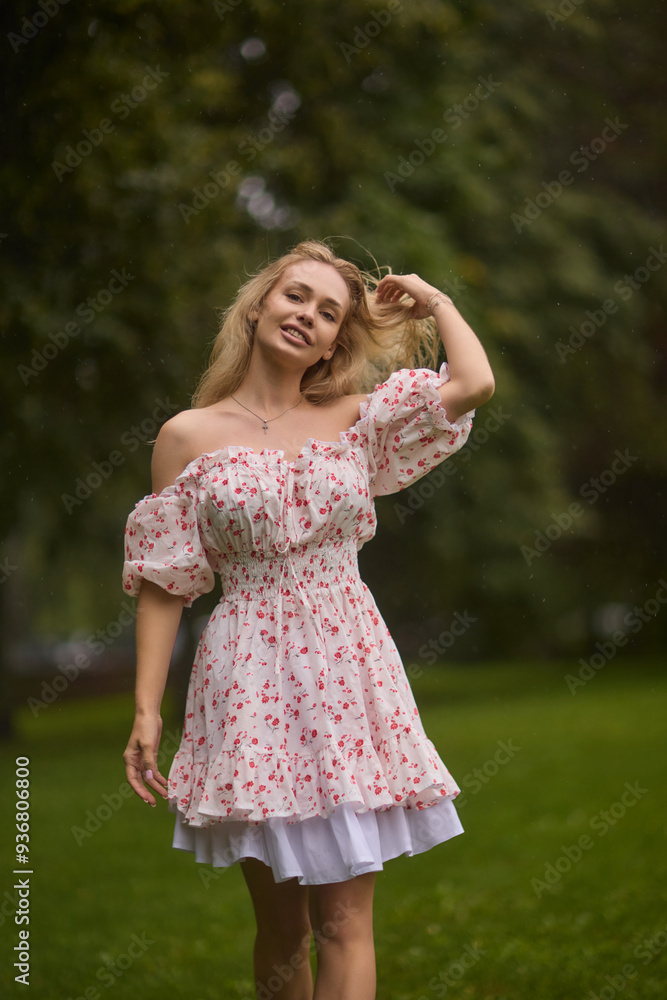 A Beautiful and Elegant Young Woman in a Lovely Summer Dress Posing Gracefully Outdoors A Beautiful and Elegant Young Woman in a Lovely Summer Dress Posing Gracefully Outdoors