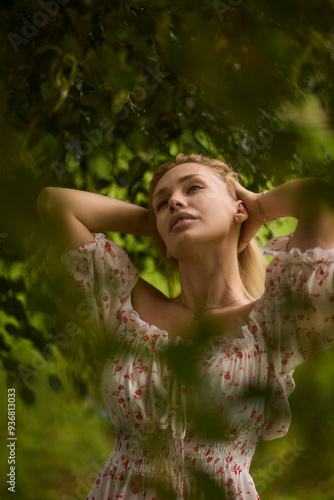 A Beautiful and Elegant Young Woman in a Lovely Summer Dress Posing Gracefully Outdoors