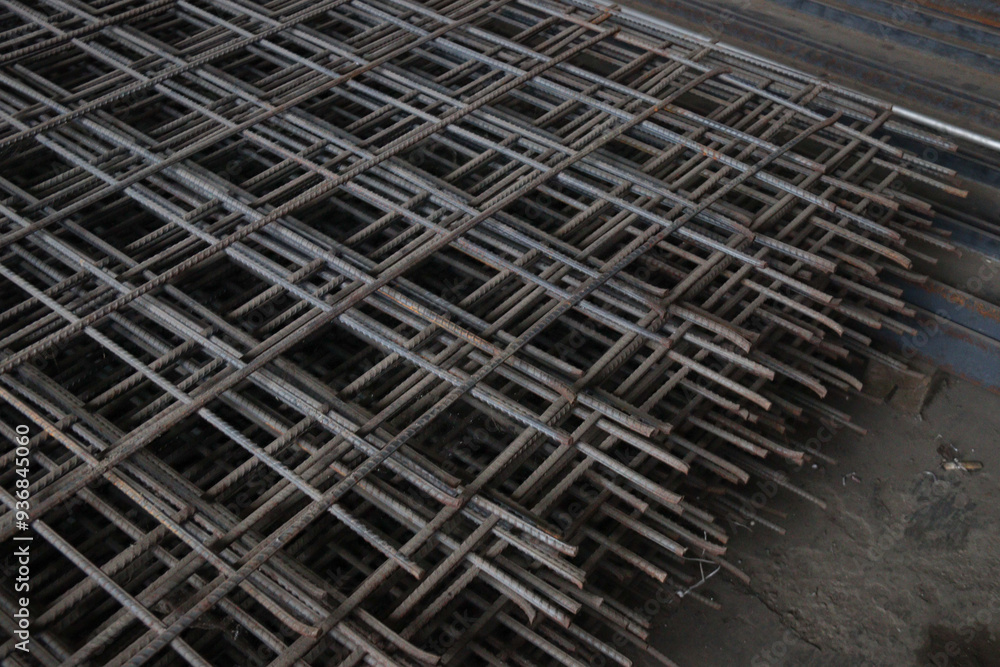 Close-up of stacked steel rebar grids, essential for reinforcing concrete in construction projects. Ideal for illustrating industrial and architectural concepts Close-up of stacked steel rebar grids, essential for reinforcing concrete in construction projects. Ideal for illustrating industrial and architectural concepts