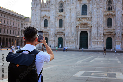 A tourist photographing the stunning Milan Cathedral, showcasing architectural beauty and exploration.