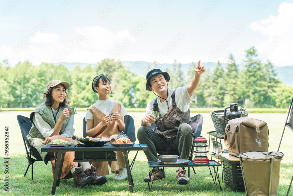 公園・キャンプ場でデイキャンプ・キャンプ・バーベキューを楽しむ仲良しのファミリー
