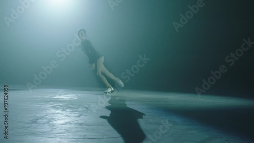 Figure skater spinning under spotlight