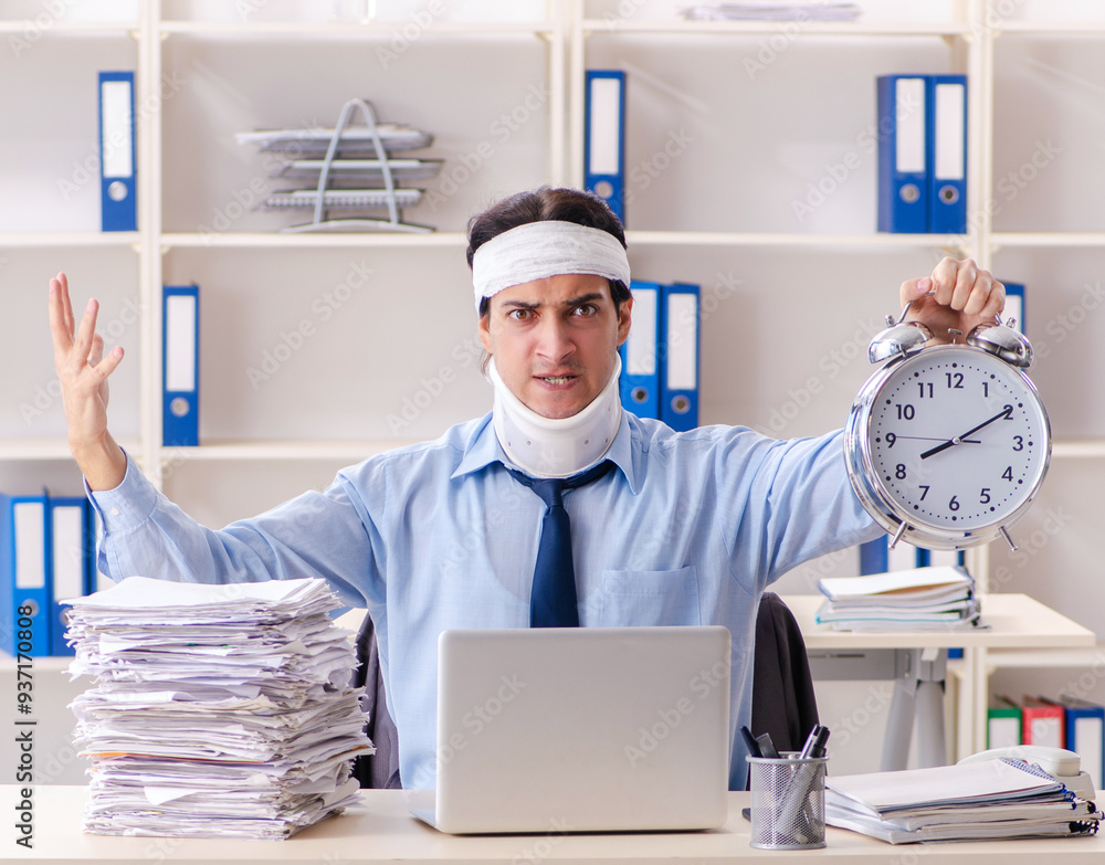 Young injured male employee working in the office Young injured male employee working in the office