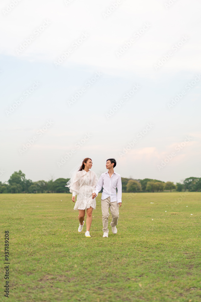 Happy young Asian couple in bride and groom clothing Happy young Asian couple in bride and groom clothing