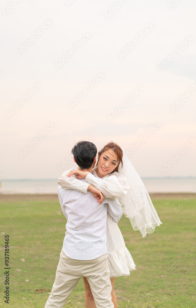 Happy young Asian couple in bride and groom clothing Happy young Asian couple in bride and groom clothing