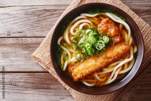 Udon, Thick wheat flour noodles served in a simple broth made from soy sauce, mirin, and dashi, often topped with tempura, green onions, and kamaboko (fish cake). photo