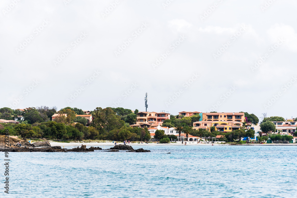 From the sandy shores of Di Bados, the rugged Sardinian coastline unfolds, where elegant villas nestle among the rocks and greenery. From the sandy shores of Di Bados, the rugged Sardinian coastline unfolds, where elegant villas nestle among the rocks and greenery.