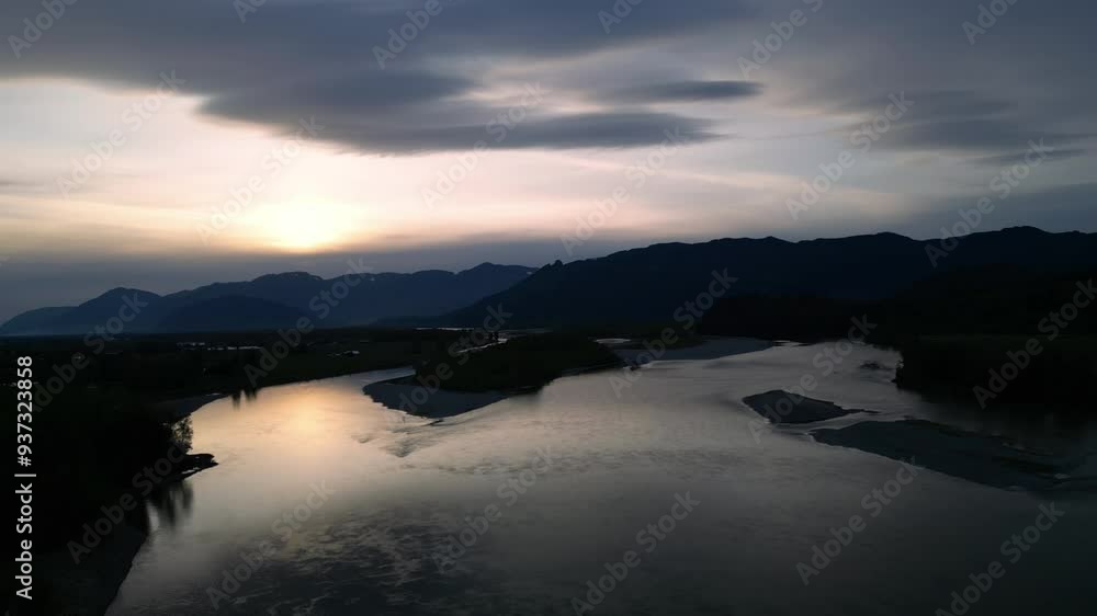 Early morning sunrise over the Fraser River near Chilliwack, British Columbia. Beautiful dawn with clouds in the sky and mountains in the background. British Columbia, Canada. Early morning sunrise over the Fraser River near Chilliwack, British Columbia. Beautiful dawn with clouds in the sky and mountains in the background. British Columbia, Canada.