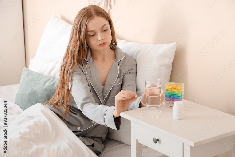 Young woman with glass of water taking sleeping pills in bedroom Young woman with glass of water taking sleeping pills in bedroom