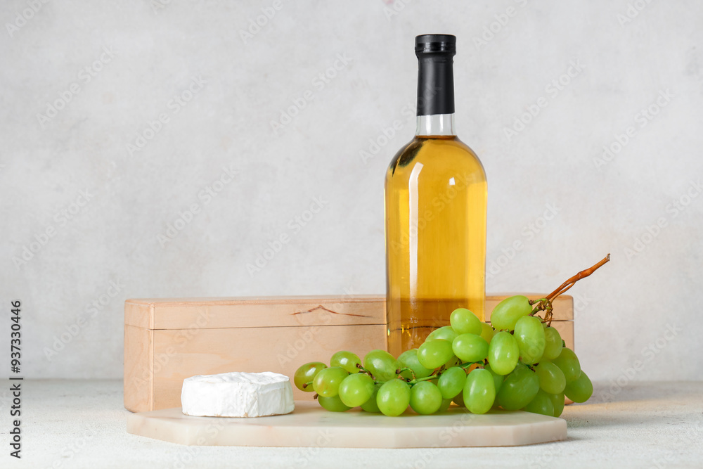 Naklejka premium Box with bottle of wine, glasses, grapes and Camembert cheese on white grunge background