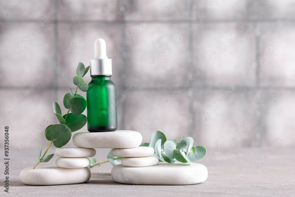 Spa stones and bottle of eucalyptus essential oil on grunge background, closeup Spa stones and bottle of eucalyptus essential oil on grunge background, closeup