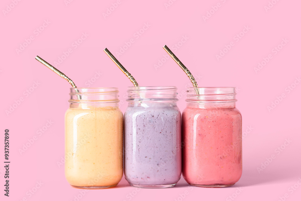 Mason jars of different fresh smoothie on pink background Mason jars of different fresh smoothie on pink background